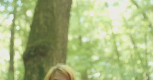森の日当たりの良い光の中でブロンドの女性の肖像 — ストック動画