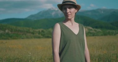 Güneşli yaz öğleden sonra çayırında poz veren kadın..