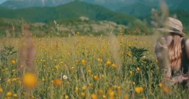Düşünen kadın güneşli bir çayırda oturur.
