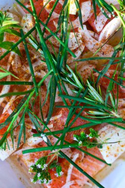 Çiğ somon fileto soğan ve bitkiler bir tabakta