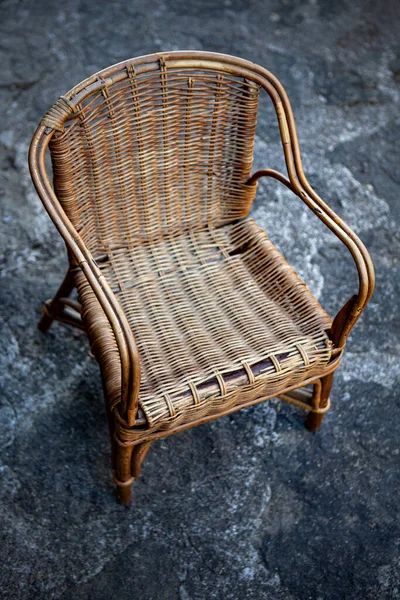 Old wicker chair on a stone floor