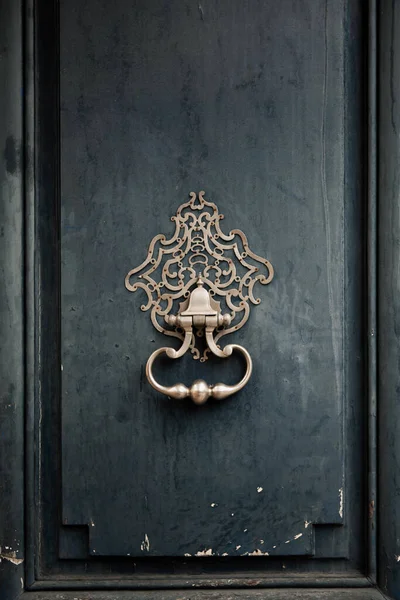 Bronze door knocker on a used wooden door