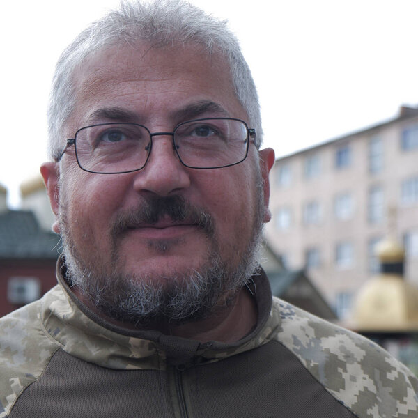 Bearded Ukrainian military man with glasses smiles. High quality photo