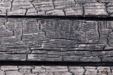 Koyu renkli kaba yanık ahşabın desenli tek renkli arkaplanı ve sıralarda çatlaklar.