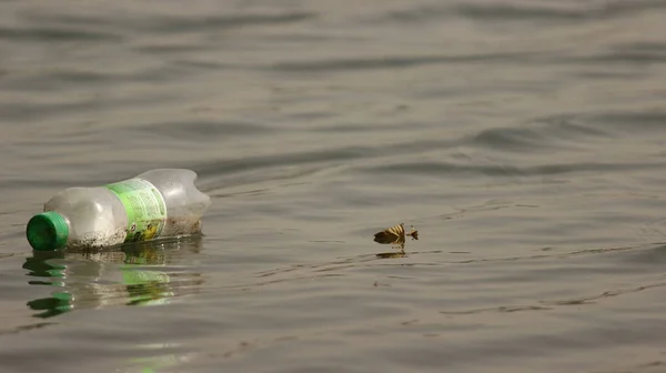 the trash is a small bottle of water. this image is a lot of a large garbage boat.