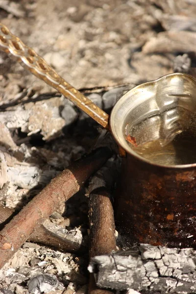 a man's hand pouring a tea in his ground.