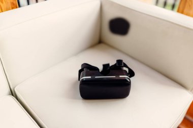 Beyaz koltukta izole edilmiş sanal gerçeklik kaskı.