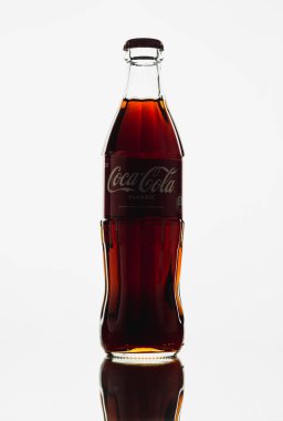 Beyaz arka planda cam Coca-Cola şişesi.
