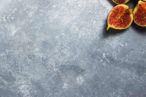 Gri arkaplanda incir parçaları.