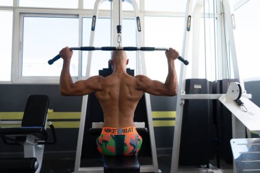 Beyaz tenli sporcu spor salonunda çalışıyor.