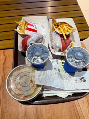 İki KFC menüsü: hamburger, patates kızartması, Pepsi içeceği.