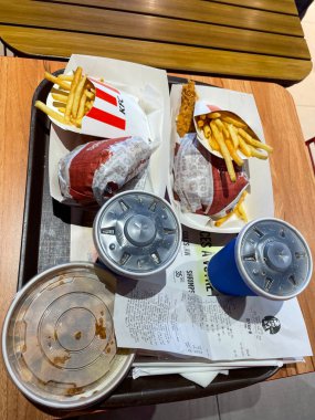 İki KFC menüsü: hamburger, patates kızartması, Pepsi içeceği.