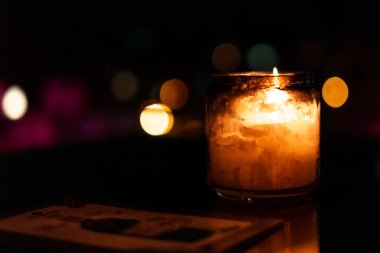 Karanlık bir odada yansıması olan cam mum.