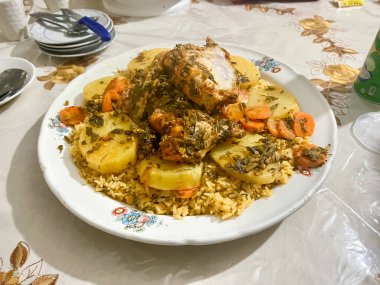 Sebzeli buğulanmış tavuk ve beyaz bir tabakta pilav.