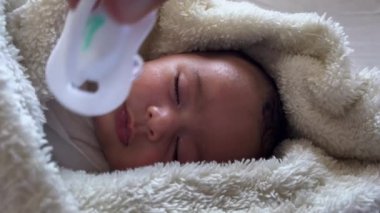 Sweet peaceful baby lying on a white bedsheet enjoy daytime nap