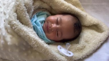 Sweet peaceful baby lying on a white bedsheet enjoy daytime nap