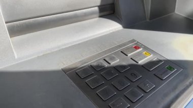 Tanınmayan bir adam ATM 'den para çekiyor.