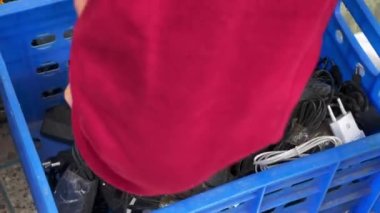 Unrecognizable man looking for a charger in a street market