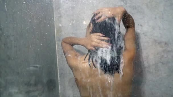 Πίσω Όψη Γυμνής Γυναίκας Που Λούζει Μαλλιά Σαμπουάν Ενώ Κάνει — Αρχείο Βίντεο