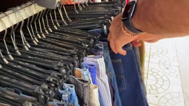 Hombre Irreconocible Seleccionando Pantalones Cortos Una Tienda Ropa Segunda Mano — Vídeo de stock