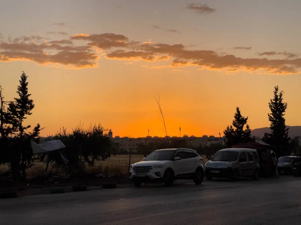 Kilka Samochodów Jadących Drodze Sylwetką Zachodzącego Słońca Niebo Tle — Zdjęcie stockowe