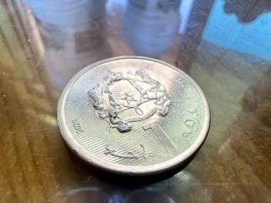 Closeup of a Moroccan Dirham coin on a brown table