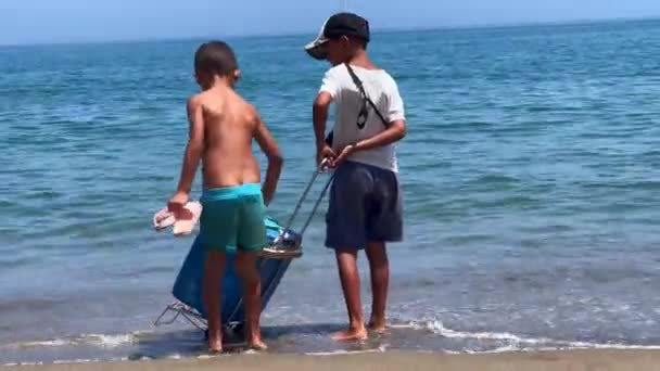 Young Kid Pushing Food Box Him Beach — 图库视频影像