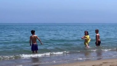 Group of kids playing together on the seashore