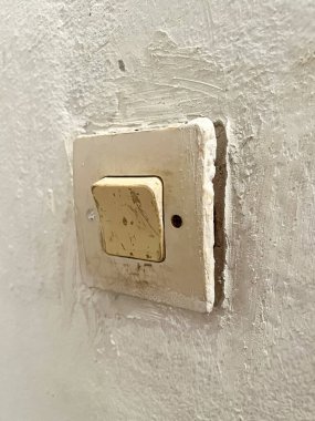 Old fashioned light switch mounted on a white wall