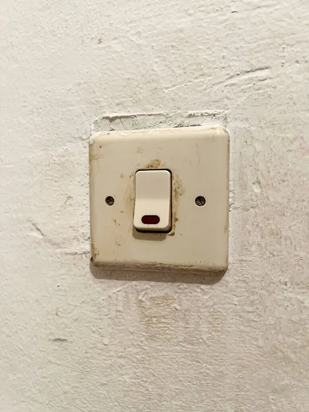 Old fashioned light switch mounted on a white wall