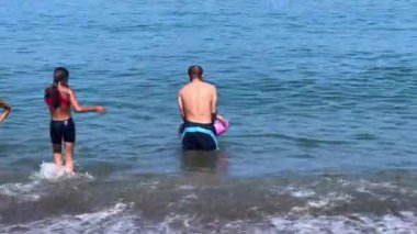 Akdeniz 'de çocuklarıyla yüzen bir adam.