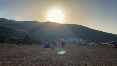 İnsanlar sahilde günbatımı sırasında