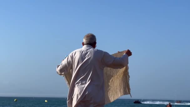 在海滩拿着地毯的男人 — 图库视频影像