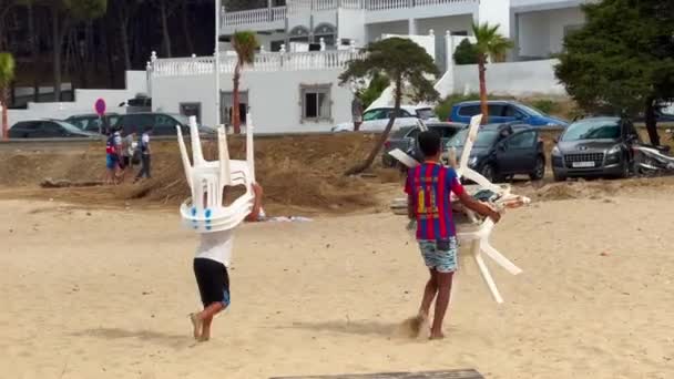 Dois Meninos Movendo Cadeiras Plástico Mesas Praia — Vídeo de Stock