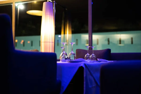 Empty dinner table with wineglasses and dishes on it