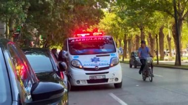 Ambulans aracı yol kenarına park etmiş, acil durum ışıkları yanıp sönüyor.