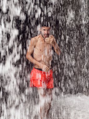 Şelalenin altında duran adam