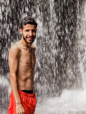 Şelalenin altında duran adam