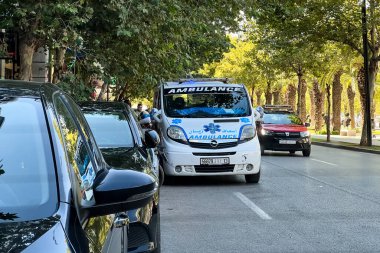 Ambulans aracı yol kenarına park etmiş, acil durum ışıkları yanıp sönüyor.