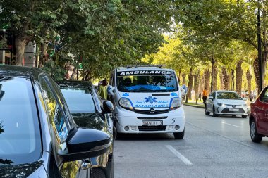 Ambulans aracı yol kenarına park etmiş, acil durum ışıkları yanıp sönüyor.