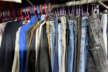 Pantolonlar ikinci el mağazasında askıda asılı.