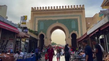 Fez 'in eski Medine' sindeki Mavi Kapı 'nın yakınında yürüyen insanlar.