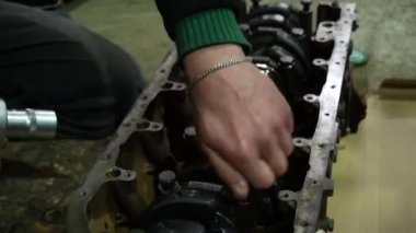 Bir silindir bloğuna krank mili kuran bir araba motoru monte ediliyor