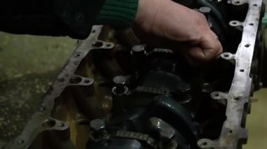 Bir silindir bloğuna krank mili kuran bir araba motoru monte ediliyor