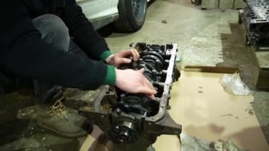 Bir silindir bloğuna krank mili kuran bir araba motoru monte ediliyor