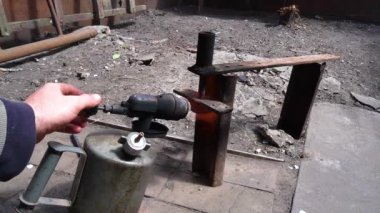 gasoline burner heating metal to unscrew the old bolt and nut