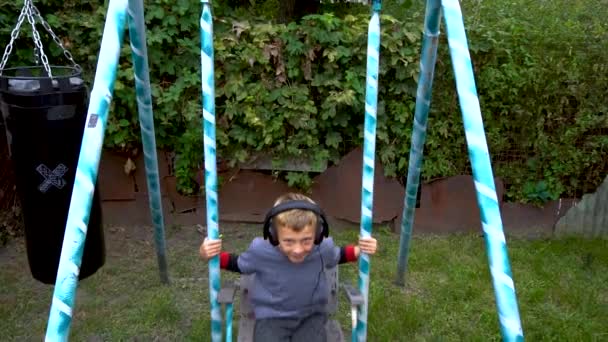 Boy Listens Music Headphones Yard — Stockvideo