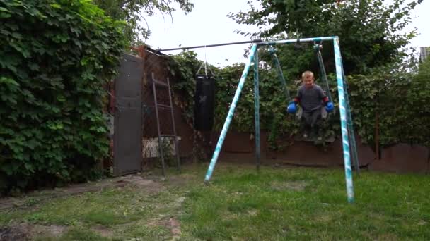 Boy Rests Training Blue Gloves Yard — стоковое видео