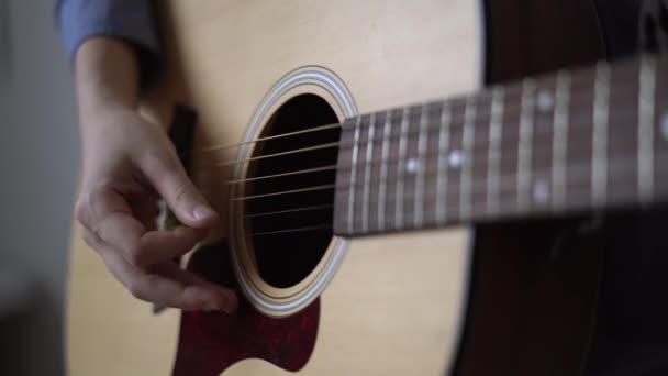 Студент-музыкант играет на акустической гитаре, онлайн-курсы для начинающих — стоковое видео