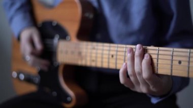 Gitarist elektro gitar ve şarkı sözü için solo beste yapıyor.